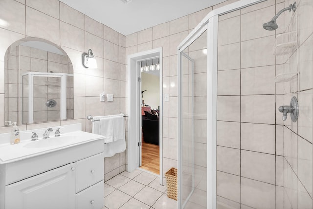 bathroom featuring tile walls, vanity, tile patterned floors, and walk in shower