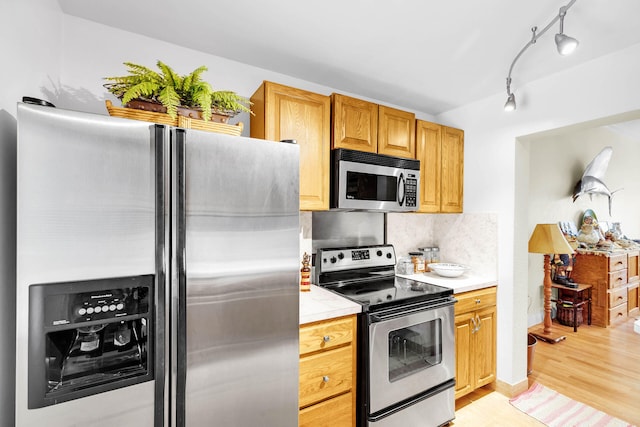 kitchen featuring decorative backsplash, light hardwood / wood-style floors, and appliances with stainless steel finishes