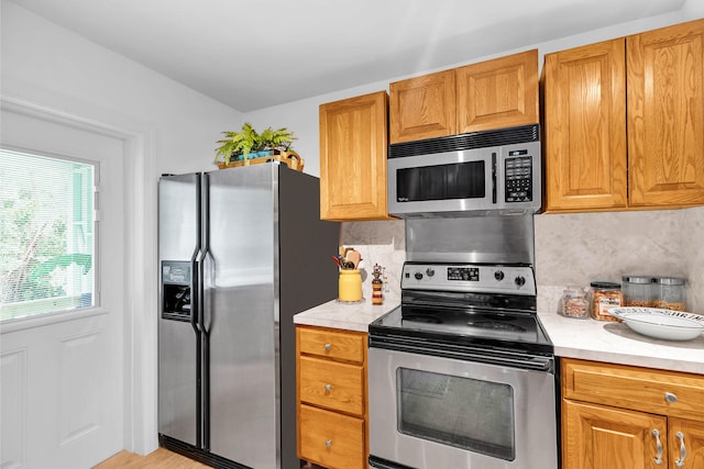 kitchen with stainless steel appliances and decorative backsplash