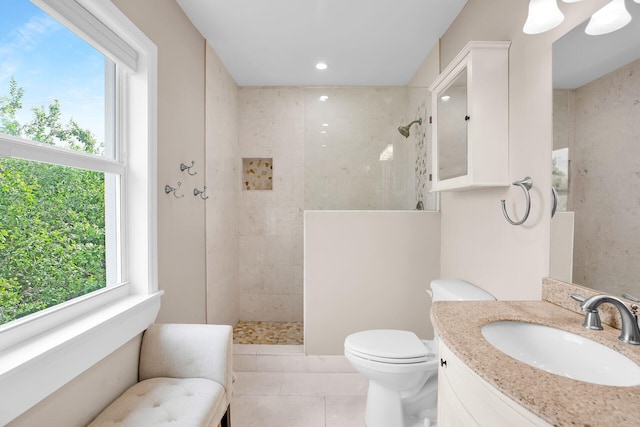 bathroom featuring tiled shower, vanity, tile patterned floors, and a wealth of natural light