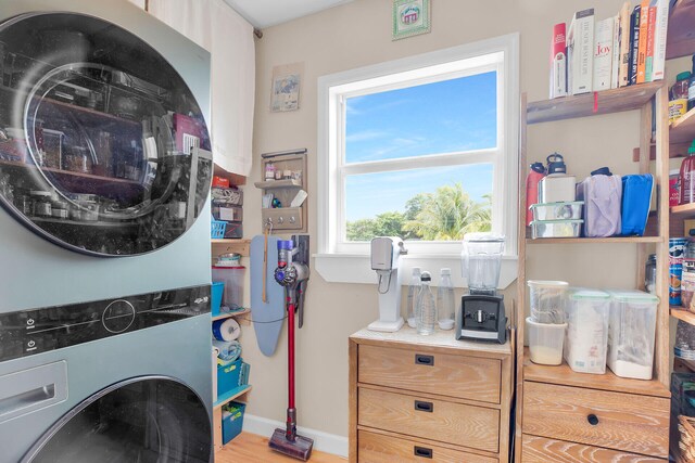 clothes washing area with stacked washer / dryer