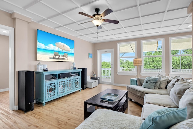 living room featuring coffered ceiling, a healthy amount of sunlight, and light wood-type flooring