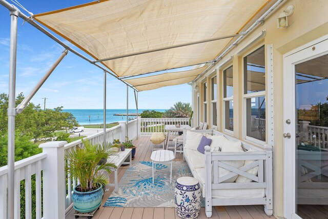 balcony with a deck with water view and an outdoor hangout area