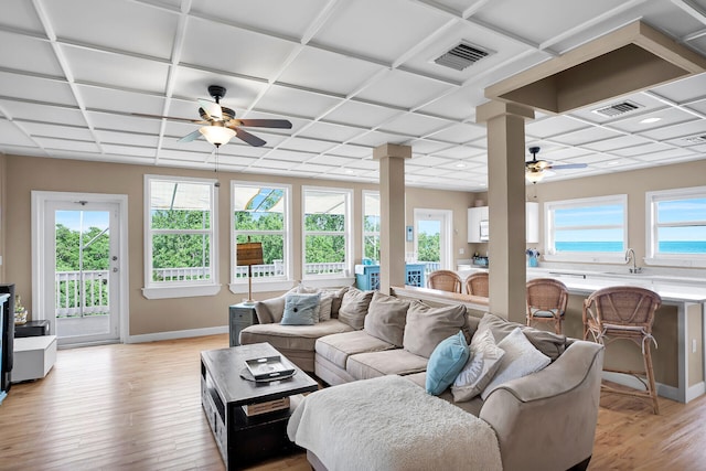 living room with decorative columns, a paneled ceiling, ceiling fan, and light hardwood / wood-style flooring