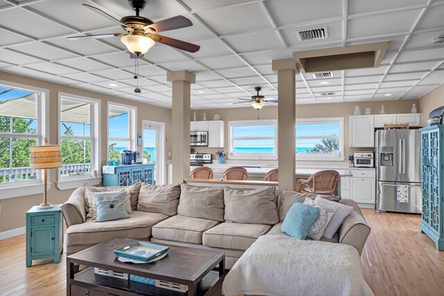 living room featuring ceiling fan, a paneled ceiling, light hardwood / wood-style flooring, and a wealth of natural light