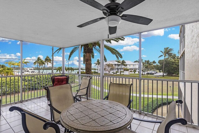 sunroom with a ceiling fan and a residential view