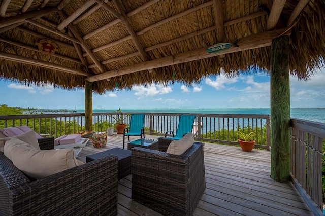 deck with a water view, an outdoor hangout area, and a gazebo