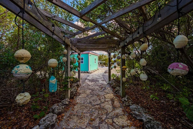 view of yard featuring a storage shed, a pergola, and an outbuilding