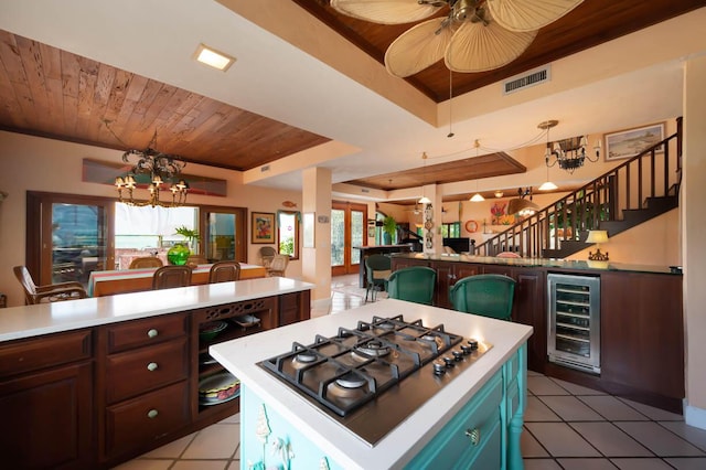 kitchen with wine cooler, wood ceiling, visible vents, light countertops, and a tray ceiling