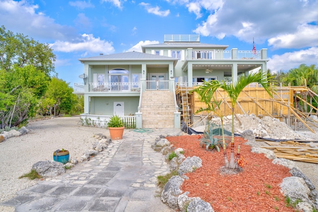 view of front of property with stairs, french doors, a balcony, and a ceiling fan