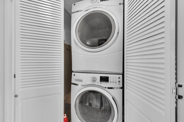 clothes washing area featuring stacked washing maching and dryer