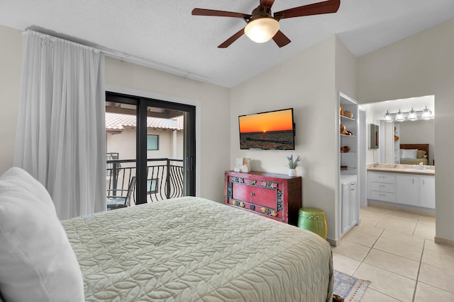 bedroom featuring vaulted ceiling, ensuite bath, light tile patterned floors, access to exterior, and a textured ceiling