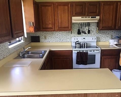 kitchen featuring sink, electric range, and backsplash