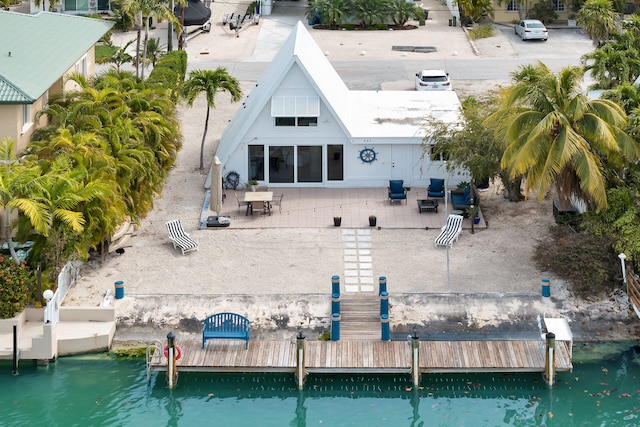 rear view of house with a water view and a patio area