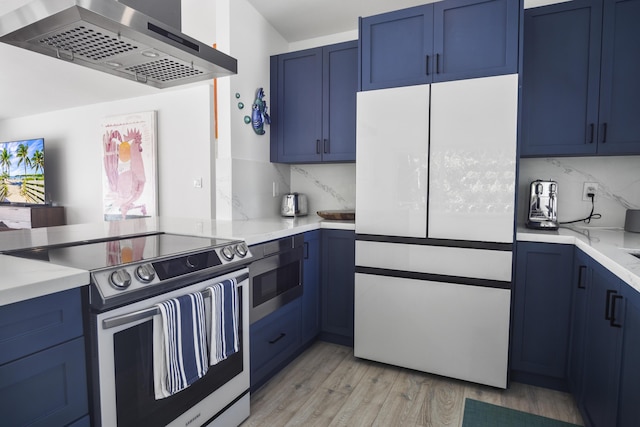 kitchen with stainless steel appliances, range hood, light hardwood / wood-style floors, and blue cabinets