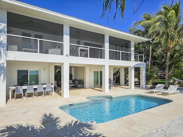 back of property with an outdoor living space, a patio area, a balcony, and ceiling fan