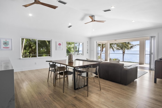 dining room with a water view, ceiling fan, and hardwood / wood-style flooring