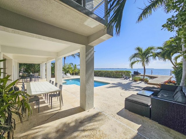 view of swimming pool featuring a patio, a water view, and an outdoor hangout area