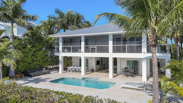 back of property with a balcony, an outdoor hangout area, and a patio area