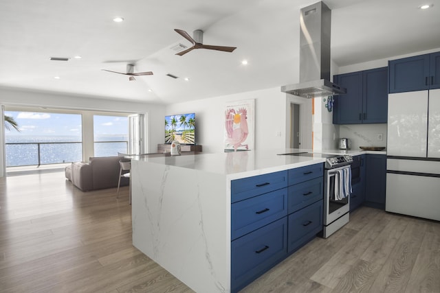 kitchen featuring extractor fan, white refrigerator, a water view, blue cabinetry, and stainless steel electric range