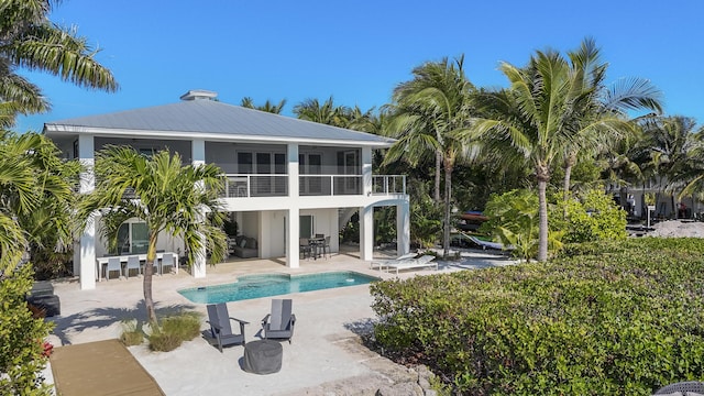 back of house featuring a patio area, a sunroom, and a balcony