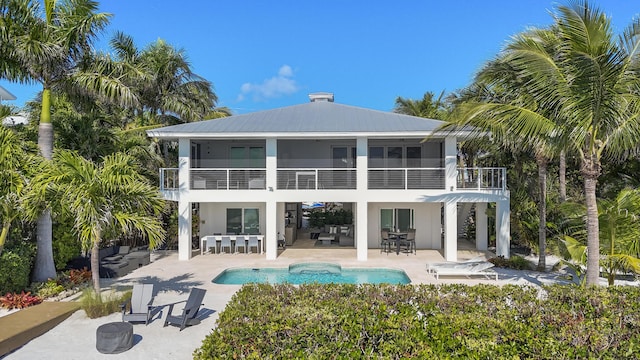 back of property featuring a balcony and a patio area