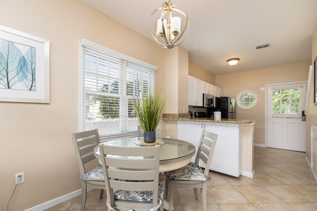 tiled dining space with an inviting chandelier