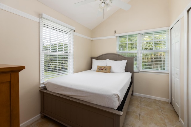 tiled bedroom with multiple windows, lofted ceiling, and ceiling fan