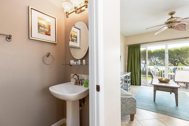 bathroom with tile patterned flooring and ceiling fan with notable chandelier