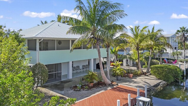 rear view of property featuring a sunroom and a patio