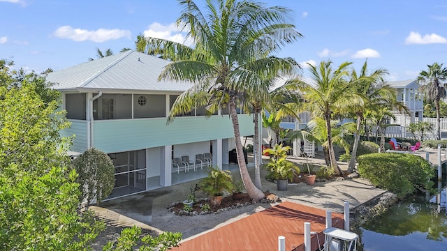 rear view of property featuring a sunroom and a patio