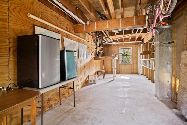 basement featuring stainless steel refrigerator