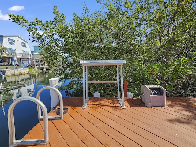 wooden terrace with a water view and a boat dock