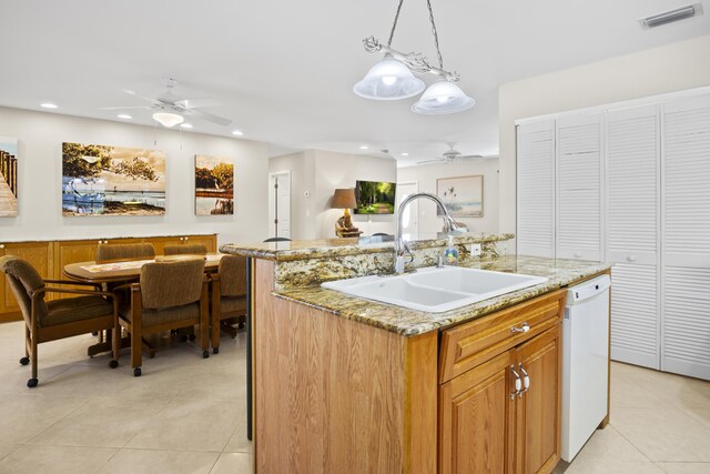 kitchen with pendant lighting, white dishwasher, sink, and a center island with sink