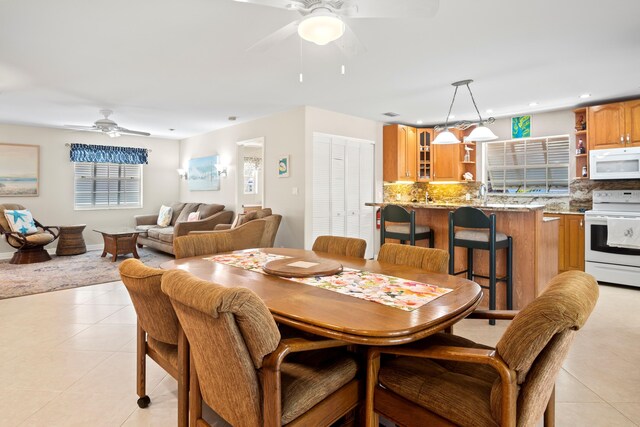 dining space featuring light tile patterned flooring and ceiling fan