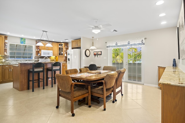 tiled dining room with sink, french doors, and ceiling fan