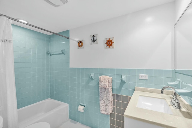 full bathroom featuring shower / bath combo, tile walls, vanity, and toilet