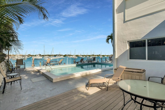 view of pool featuring a water view and a hot tub