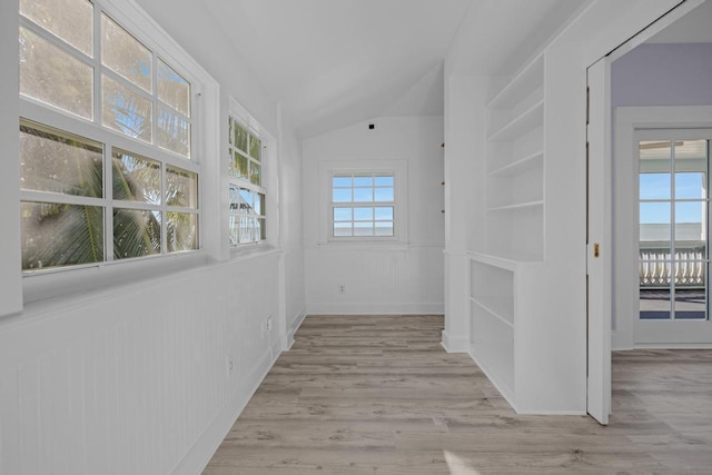 hall featuring vaulted ceiling and light wood-type flooring