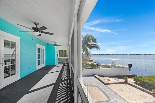 balcony featuring a water view and ceiling fan