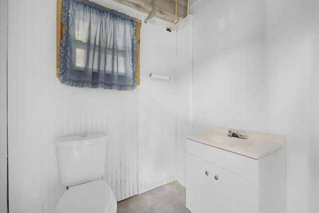 bathroom featuring vanity, toilet, and concrete flooring