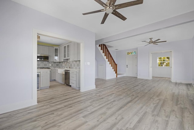 unfurnished living room featuring ceiling fan, wine cooler, and light hardwood / wood-style floors