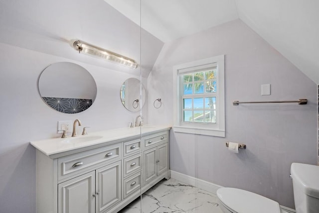 bathroom featuring lofted ceiling, vanity, and toilet