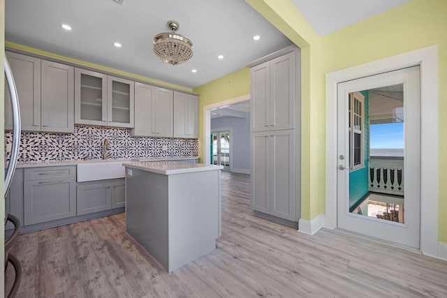 kitchen featuring gray cabinetry, sink, light hardwood / wood-style flooring, and a kitchen island