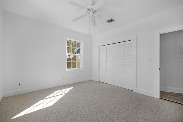 unfurnished bedroom featuring ceiling fan, light carpet, and a closet