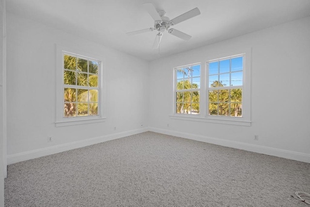 carpeted spare room featuring ceiling fan