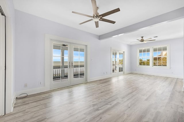 unfurnished room featuring beamed ceiling, light hardwood / wood-style flooring, ceiling fan, and french doors