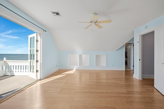 bonus room with lofted ceiling, light wood-type flooring, ceiling fan, and a water view