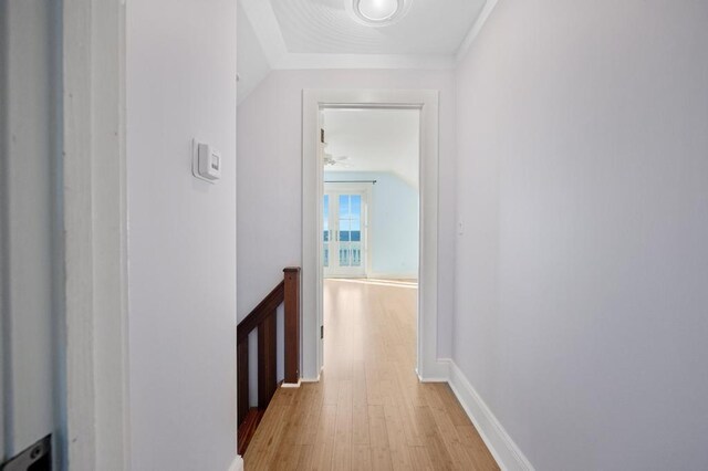 corridor with vaulted ceiling and light hardwood / wood-style floors