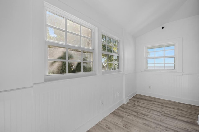 empty room with lofted ceiling and light wood-type flooring